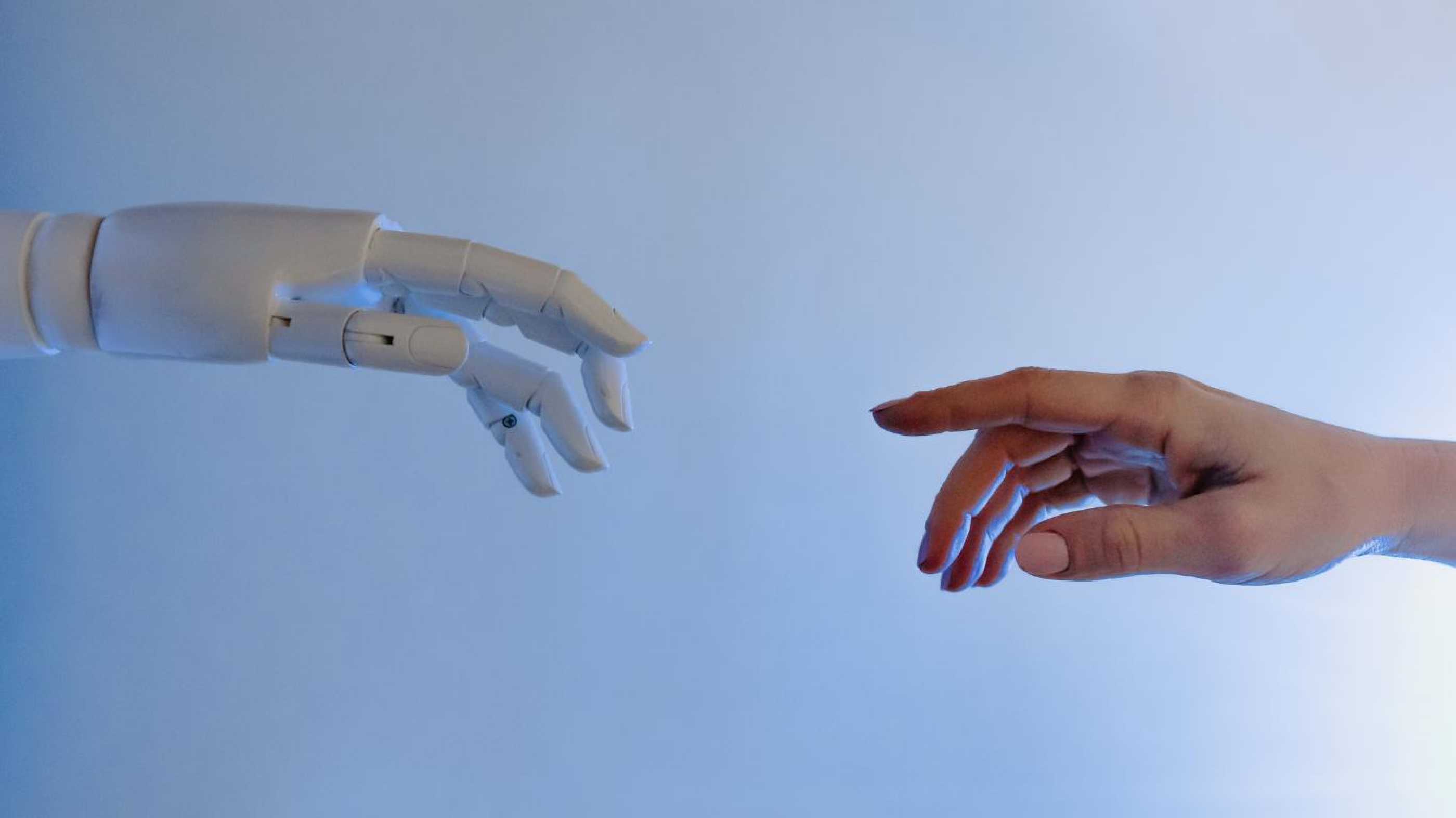 A robot and a human hand reaching towards each other