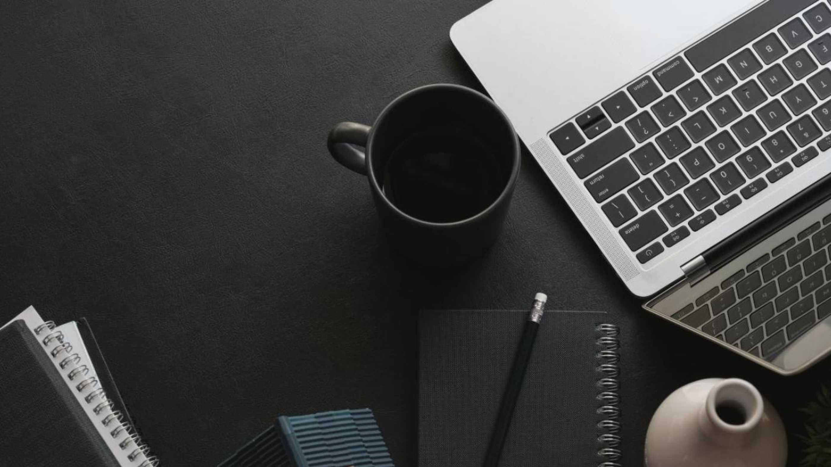 open laptop with a coffee cup next to it